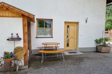 Außenbereich mit Tisch, Stühlen und Grill